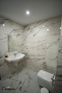 基尔科沃Hotel Kirkovo的白色的浴室设有水槽和卫生间。