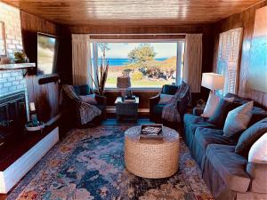 塞奎姆Dungeness Bay Cottages的带沙发和大窗户的客厅