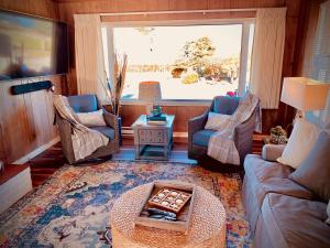 塞奎姆Dungeness Bay Cottages的带沙发和椅子的客厅以及窗户。