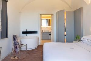 加里Ramo d'Aria Etna Boutique Hotel的一间带一张床和浴缸的卧室以及一间浴室