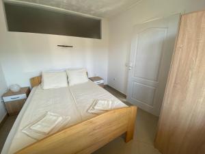 索科矿泉村Apartmani Bambi Sokobanja的卧室配有带白色床单的床和门。