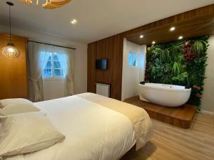 坎波斯杜若尔当阿尔弗雷多何塞宾馆的一间带浴缸的卧室和一张带大窗户的床