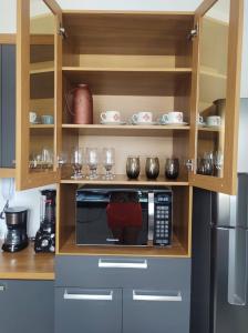 帕尔马斯AP confortável para sua família的厨房配有微波炉和冰箱。