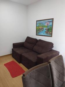 帕尔马斯AP confortável para sua família的客厅配有棕色沙发和绘画