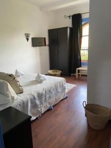 舍夫沙万阿勒哈利法酒店的卧室配有白色的床,铺有木地板
