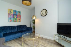 特伦特河畔伯顿Heath House的客厅配有蓝色的沙发和时钟