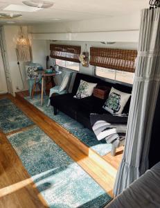 蒂梅丘拉Rustic Farm Stay的客厅配有黑色沙发和蓝色地毯。