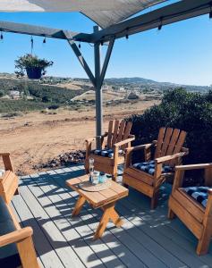 蒂梅丘拉Rustic Farm Stay的庭院配有两把椅子、一张桌子和一把遮阳伞