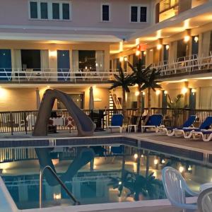 威尔伍德克拉斯特克罗尼海滩汽车旅馆的一座带椅子的游泳池和一座建筑的酒店
