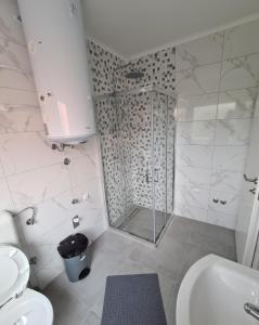 布戈伊诺Apartmani Bugojno的带淋浴、卫生间和盥洗盆的浴室