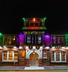 CwmcarnCwmcarn Hotel & Bunkhouse的一座紫色和绿灯的建筑