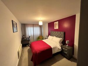 布赖尔利希尔Spacious 1 bed relocation apartment free parking,的一间卧室配有一张红色墙壁的床
