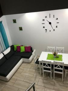 贡斯基Delfinek - Domki Apartamenty的客厅配有沙发和墙上的时钟