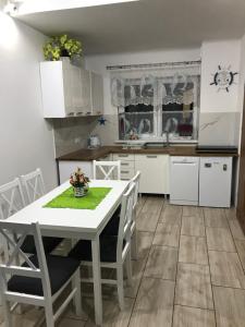 贡斯基Delfinek - Domki Apartamenty的厨房配有白色的桌椅