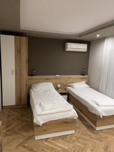 瓦尔纳Ivet Guest rooms的铺有木地板的客房内的两张床