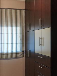 帕拉塔蒙Platamon Family Apartments的客房设有木制橱柜和窗户。