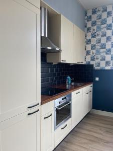 DinxperloDe Malle Molen的厨房配有白色橱柜和蓝色的墙壁