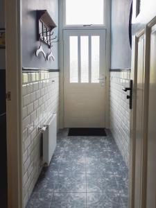 DinxperloDe Malle Molen的浴室设有门,铺有瓷砖地板。