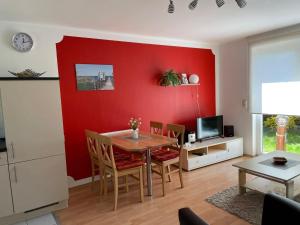 卢布明Semi-detached house, Lubmin的客厅设有桌子和红色的墙壁