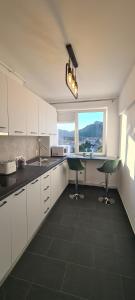 德瓦Belvedere Delux Apartment的厨房配有白色橱柜、水槽和窗户。