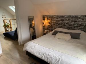 CamonLe Cocon des Hortillonnages d'Amiens的一间卧室设有砖墙和一张床