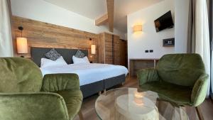 帕索罗莱维扎纳酒店的一间卧室配有一张床、两把椅子和一张桌子