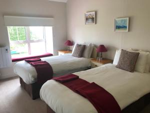 肯梅尔Gortamullen House, Kenmare的酒店客房设有两张床和窗户。