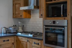 里雾诗Charming Chalet With Garden In Les Houches的厨房配有木制橱柜和炉灶烤箱。
