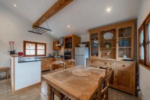 里雾诗Charming Chalet With Garden In Les Houches的厨房配有木桌和白色冰箱。