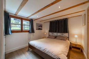 里雾诗Charming Chalet With Garden In Les Houches的一间卧室设有一张床和一个窗口
