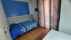 阿祖罗港Appartamento nel cuore di Porto Azzurro的客房设有一张带蓝色橱柜的床和窗户。