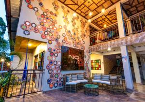 比亚维森西奥NQ Hotel Orinoquia的一座有两长椅和一棵树的建筑,墙上被画了