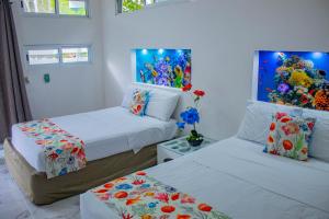 巴卡拉尔Las Fridas的一间卧室设有两张床,墙上挂着一幅画