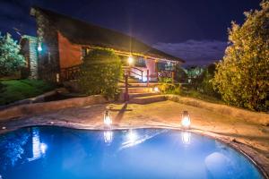 奈瓦沙Naivasha Kongoni Lodge - Lakefront Getaway的夜间在房子前面的游泳池