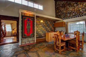 奈瓦沙Naivasha Kongoni Lodge - Lakefront Getaway的一间设有桌子和石墙的用餐室