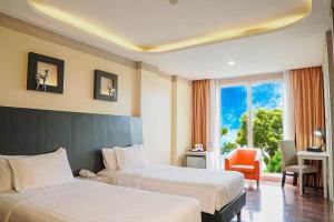 茂物ASTON Bogor Hotel and Resort的酒店客房设有两张床和窗户。