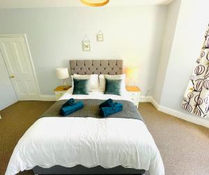 文特诺Rookley Villa, 3 Bedroom Family Apartment, Ventnor的一间卧室配有一张大床,上面有蓝色的毛巾