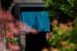 盐尻市BYAKU Narai的带有蓝色窗帘的建筑物的敞开门