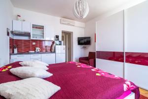 察夫塔特Apartments & Rooms Mara & Petrunjela的一间卧室配有红色的床和枕头