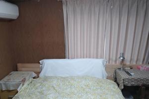 挂川市古民家リゾートハウス　ひみつきち的一间卧室配有床、灯和窗户
