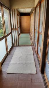 挂川市古民家リゾートハウス　ひみつきち的地板上空的走廊,有窗户和垫子