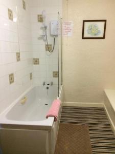 里伯斯谷地霍顿The Crown Hotel的带浴缸的浴室,配有粉红色毛巾
