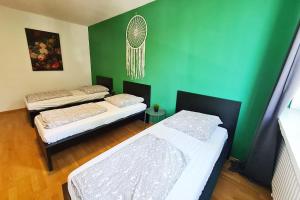 朗根费尔德Langenfeld Apartment的一间设有两张床和绿色墙壁的客房