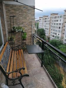瓦尔纳Апартамент в най-хубавия квартал на Варна的一张桌子上阳台的长凳