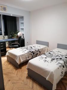 瓦尔纳Апартамент в най-хубавия квартал на Варна的一间卧室配有两张床、一张桌子和一把椅子