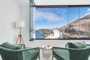 帕塔拉瓦卡Home2Book Blue Sea View Patalavaca Beach Apartment的客房设有两把绿色椅子和大窗户