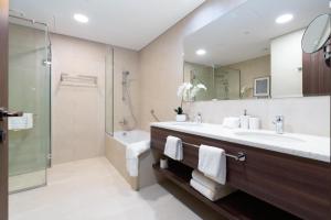 迪拜Ultimate Stay Avani next to Palm Jumeirah的一间带水槽和淋浴的浴室