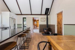 陶波River Road Spa Lodge - Broadlands Forest的厨房设有带凳子和炉灶的酒吧。