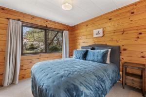 陶波River Road Spa Lodge - Broadlands Forest的一间卧室设有一张床和一个窗口