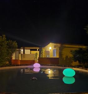 IrgoliCasa del Sole Irgoli的游泳池晚上有粉红色和紫色的灯光